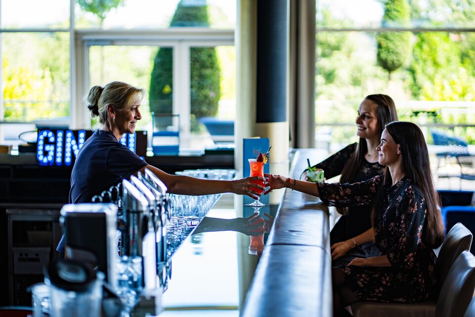 <p><p>Eine Barkeeperin serviert Cocktails an zwei Gäste an der Bar. Die Atmosphäre ist freundlich und entspannt im SPA RESORT STYRIA.</p></p> | © SPA Resort Styria