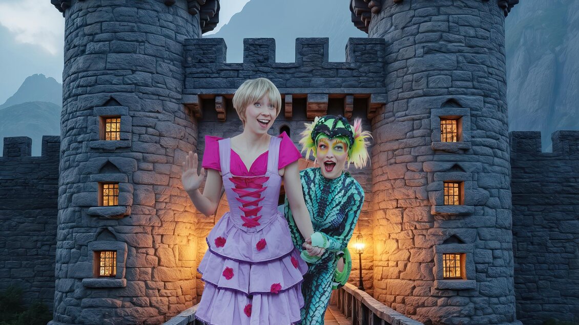 Zwei verkleidete Darsteller als Rapunzel und Geko auf einer Burgbrücke mit steinernen Türmen im Hintergrund nahe Graz. | © Märchensommer-Martin Hesz