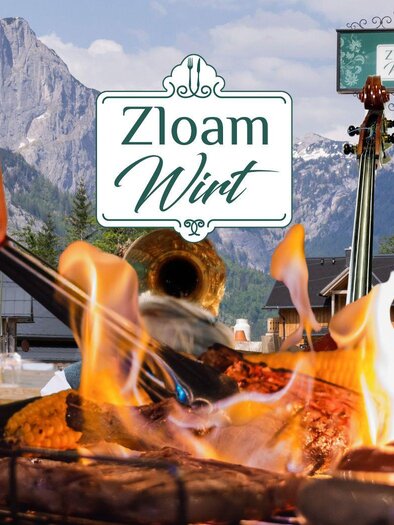 A lively barbecue party with smoky meat and a picturesque mountain view. In the background, a musician and the sign of "Zloa Wirt" can be seen. | © www.zloam.at