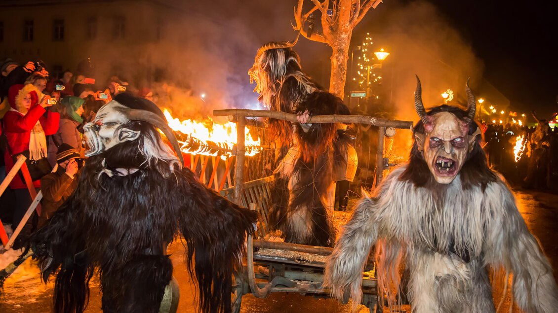 Eine festliche Dorfevent mit Menschen in gruseligen Kostümen und Fackeln. Im Hintergrund sind Zuschauer zu sehen, die die Szene beobachten. | © TV Hochsteiermark