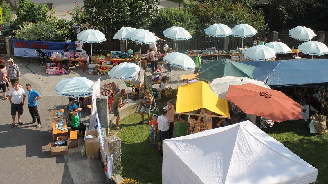 Ein bunter Markt mit vielen Ständen und Sonnenschirmen. Menschen stöbern zwischen den Ständen und genießen die Atmosphäre. | © Gemeinde Langenwang