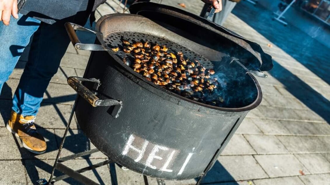 Ein über einem offenen Feuer gegrillter Kastanienstand. Die Kastanien sind in einer großen, schwarzen Pfanne sichtbar. | © Stadtgemeinde Feldbach