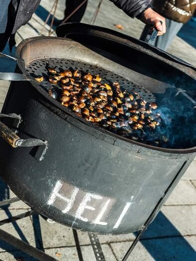 Ein über einem offenen Feuer gegrillter Kastanienstand. Die Kastanien sind in einer großen, schwarzen Pfanne sichtbar. | © Stadtgemeinde Feldbach
