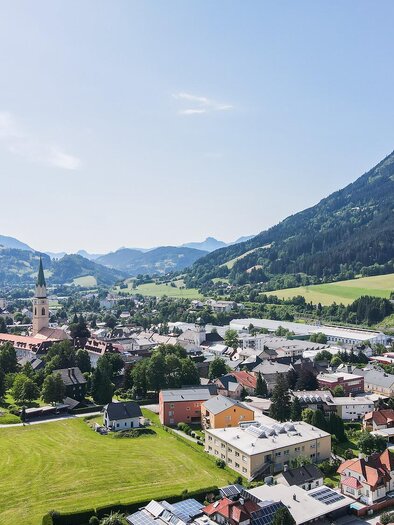 A picturesque mountain landscape with a small village. The green meadows and the mountains in the background create an idyllic atmosphere.