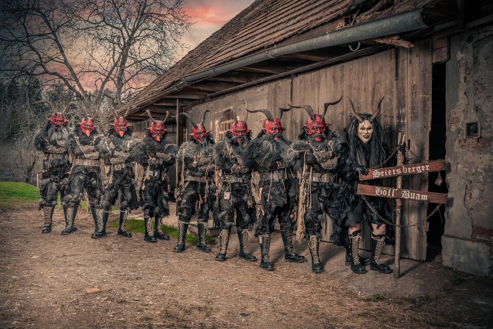 Krampusse mit rotem Gesicht und Hörnern vor einer alten Bretterbude! | © Seiersberger Höllbuam