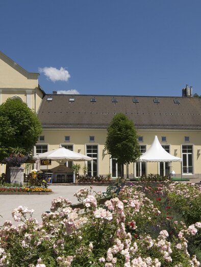 <p>Das gelbe Kur- und Congresshaus in Bad Aussee ist jährlich Zentrum von zahlreichen Veranstaltungen. Bunte Blumen und Bäume umgeben die Terrasse mit Sonnenschirmen.</p> | © TVB Ausseerland - Salzkammergut_Rastl