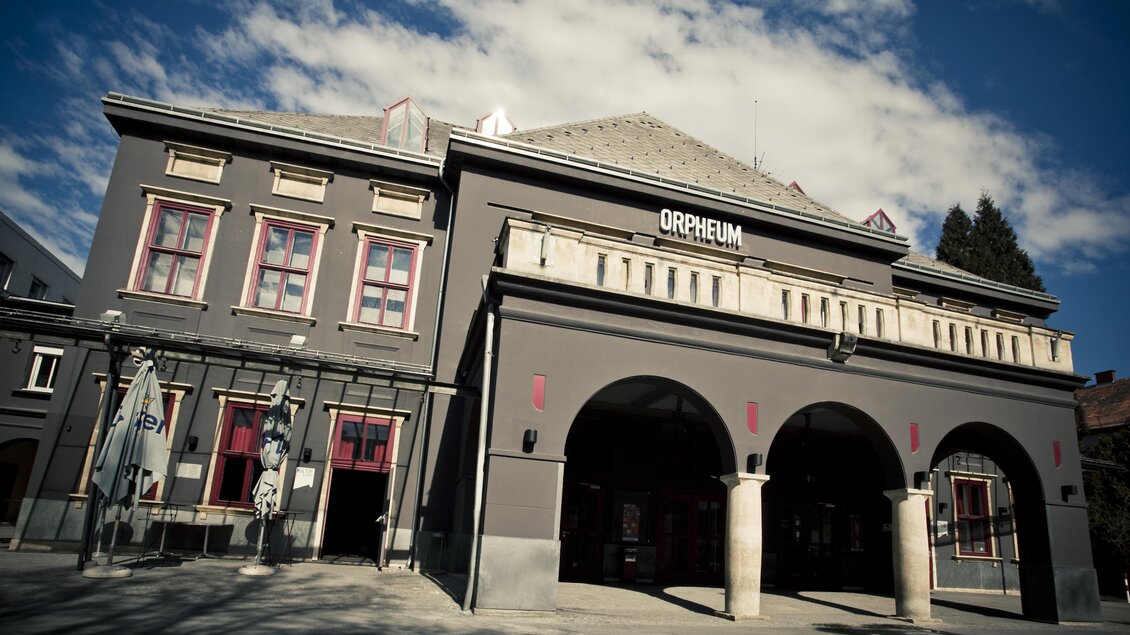 Ein historisches Gebäude mit der Aufschrift "Orpheum". Die Fassade hat große Fenster und beeindruckende Bögen. | © Spielstätten - Lupi Spuma
