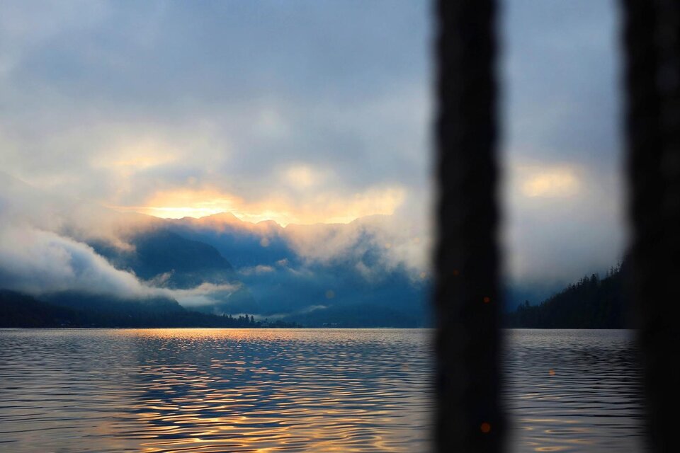 Eine ruhige Seelandschaft mit Nebel und Bergen im Hintergrund. Der Himmel leuchtet sanft bei Sonnenaufgang. | © Schifffahrt Grundlsee Toplitzsee