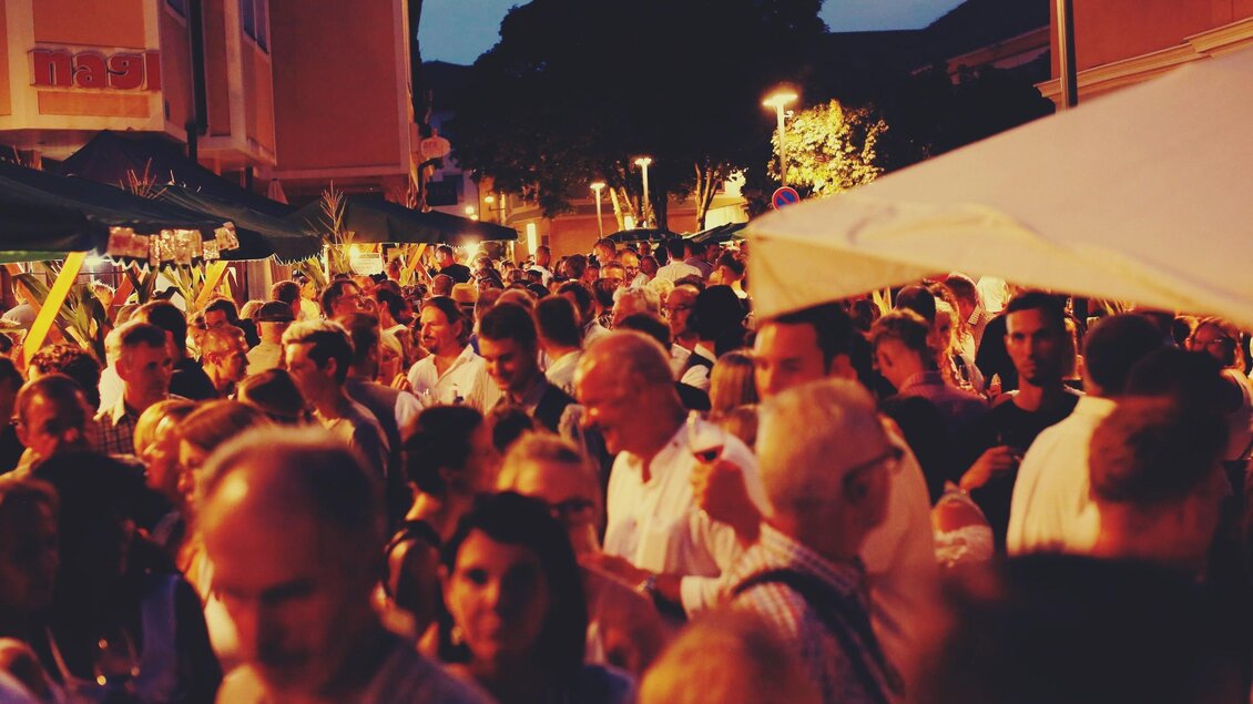 Eine lebhafte Menschenmenge bei einem nächtlichen Fest. Die Atmosphäre ist gesellig mit Ständen und Lichtern im Hintergrund. | © Oststeiermark Tourismus