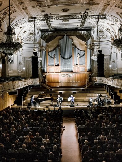 A concert hall with a large organ in the background. The audience is sitting in rows and enjoying the performance on stage. | © ivents-kulturagentur--ulrike-rauch