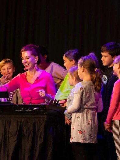 Eine Frau spielt an einem Keyboard vor einer Gruppe von Kindern. Alle schauen gespannt und lächeln. | © Sandra Paulik