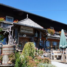 A rustic inn with blooming flowers and cozy outdoor seating. The facade is made of wood and lovingly crafted. | © Tourismusverband Oststeiermark