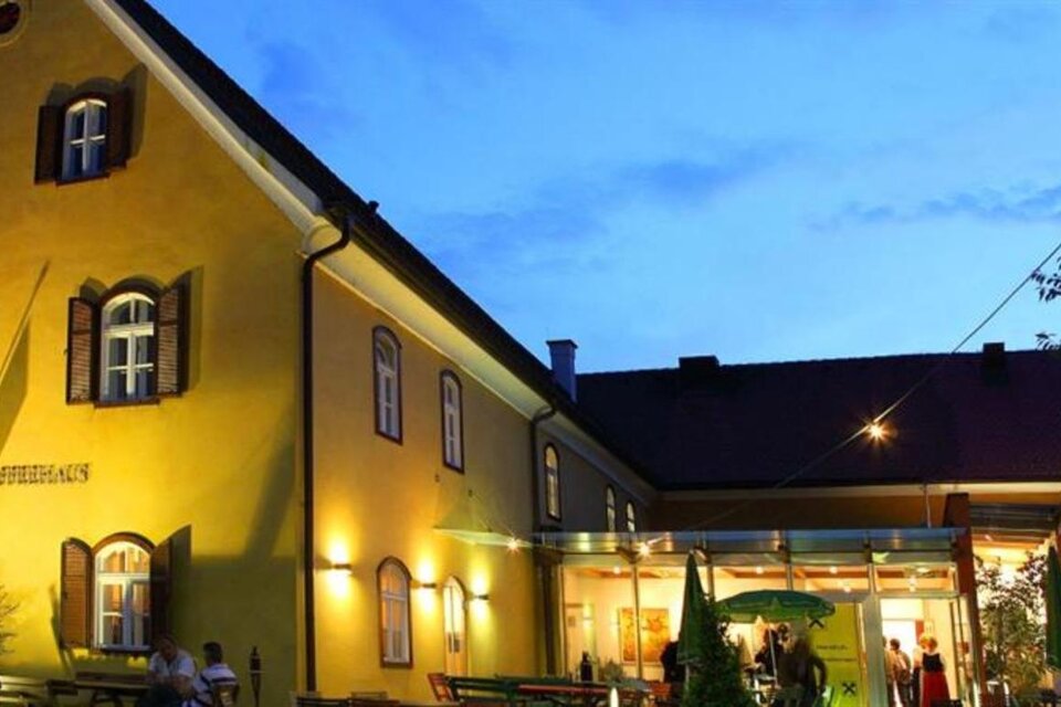 Ein einladendes gelbes Gebäude bei Abenddämmerung. Das Restaurant hat eine warme Beleuchtung und eine gemütliche Atmosphäre. | © Knielyhaus Leutschach