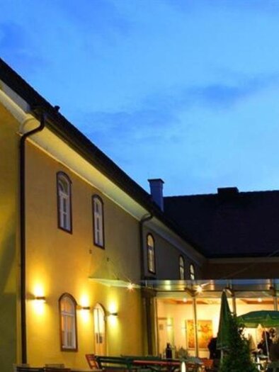 An inviting yellow building at dusk. The restaurant features warm lighting and a cozy atmosphere. | © Knielyhaus Leutschach