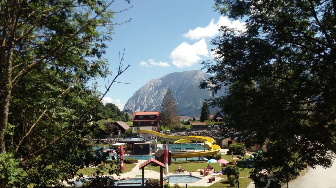 Das Alpenbad Bad Mitterndorf verfügt über ein Kinderbecken und einen Kinderspielplatz für die kleinen Gäste sowie über ein Bistro für Erfrischungen, eine große gelbe Wasserrutsche und großzügige, gepflegte Liegeflächen zum Entspannen. | © Marktgemeinde Bad Mitterndorf
