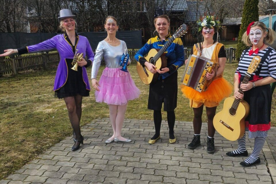 <p>Die Gruppe der fünf bunt Kostümierten vom Narrenstadl Faschingsbrief steht im Freien, und freut sich auf das lustige Vortragen in Altaussee zur Zeit des Ausseer Faschings. Sie halten Musikinstrumente und strahlen Freude aus.</p> | © Rainer Fischer