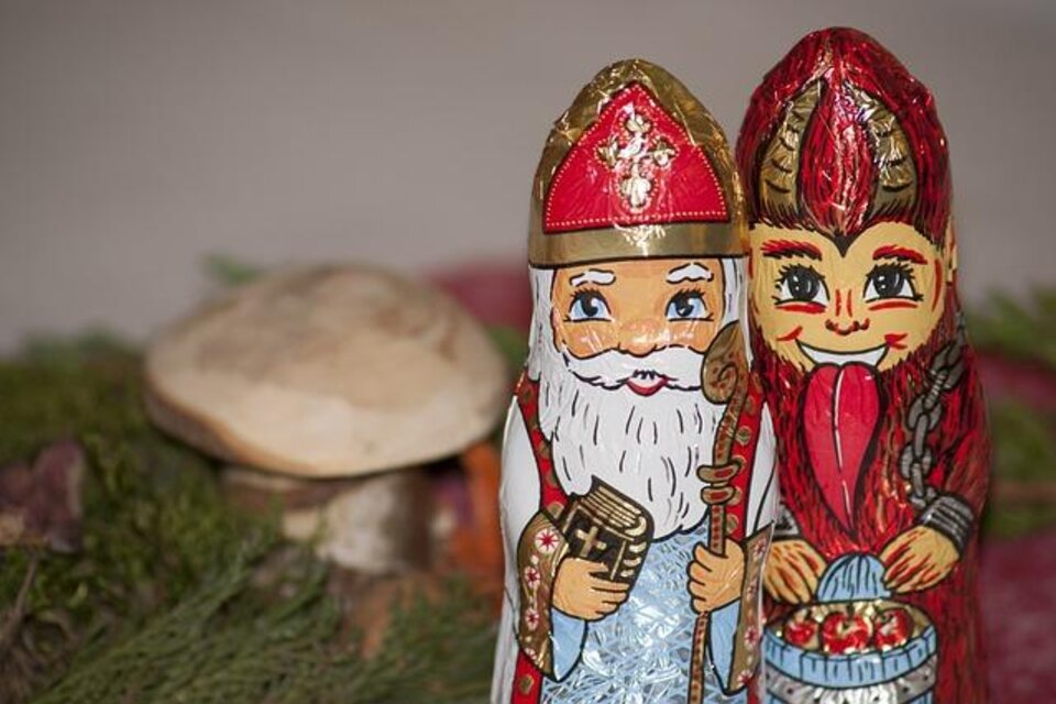 Zwei bunt bemalte Figuren, die einen Weihnachtsmann und eine Christkind darstellen. Im Hintergrund sind natürliche Elemente wie ein kleiner Pilz und grüne Zweige sichtbar. | © Pixabay