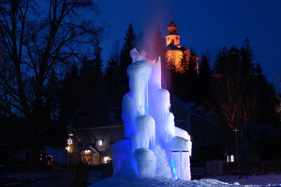 Zu sehen ist eine Kirche und im Vordergrund eine Eisskulptur. | © H. Höfer