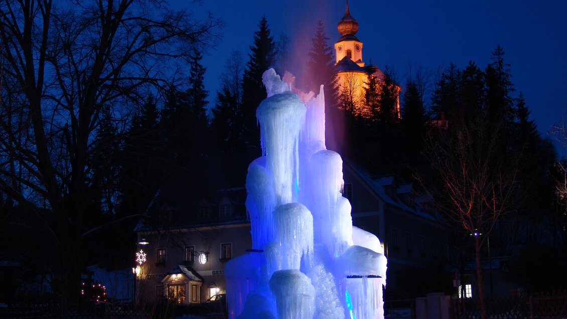 Zu sehen ist eine Kirche und im Vordergrund eine Eisskulptur. | © H. Höfer