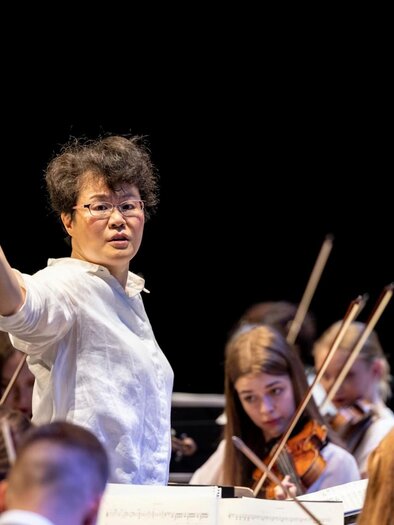Am Dirigentenpult Mei-Ann Chen mit jungen Orchestermusiker bei der Styriarte in Graz. | © Nikola Milatovic