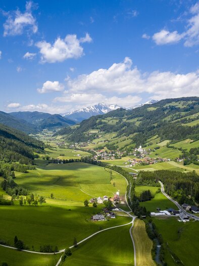 Eine malerische Landschaft mit grünen Wiesen und Bergen im Hintergrund. Der Himmel ist klar und blau, während die Wolken sanft ziehen. | © Tv Murau