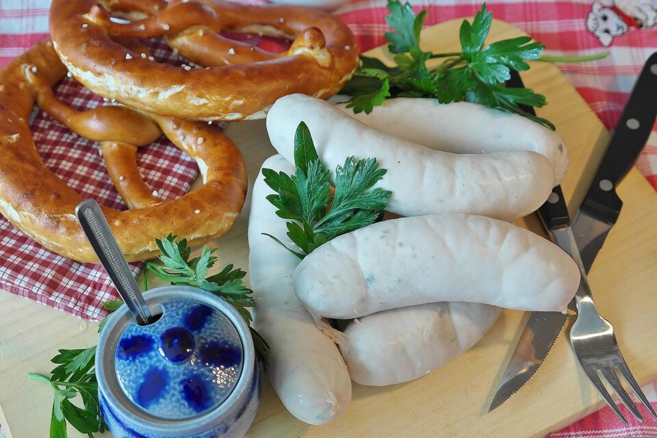 Ein Schild mit der Aufschrift "Oktoberfest" vor einem Holz Hintergrund. Oben ist ein bayerisches Rautenmuster in Blau und Weiß zu sehen. | © pixabay.com