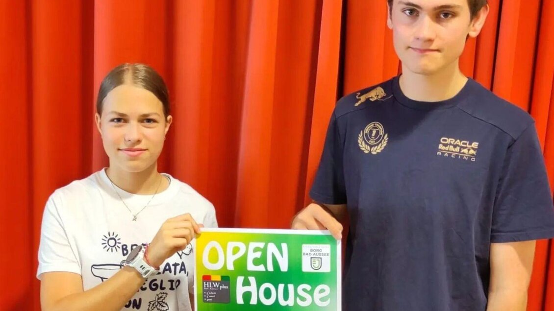 Zwei Jugendliche halten ein Plakat für einen Tag der offenen Tür an der Bundeshausschule Bad Aussee. Das Plakat enthält Informationen zur Veranstaltung und zeigt die Schule. | © Bundesschulzentrum Bad Aussee