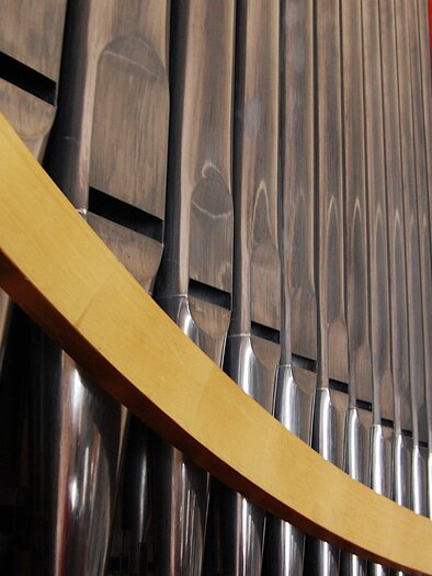 A musical instrument with shiny metal tubes and colorful accents. The image composition showcases the curved shape and structure of the instrument.