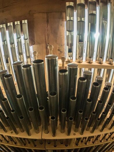 Eine Sammlung von Orgelpfeifen in verschiedenen Größen und Materialien. Das Licht reflektiert auf den metallischen Oberflächen und schafft eine interessante Atmosphäre. | ©  Prof. Karl-Heinz Schein
