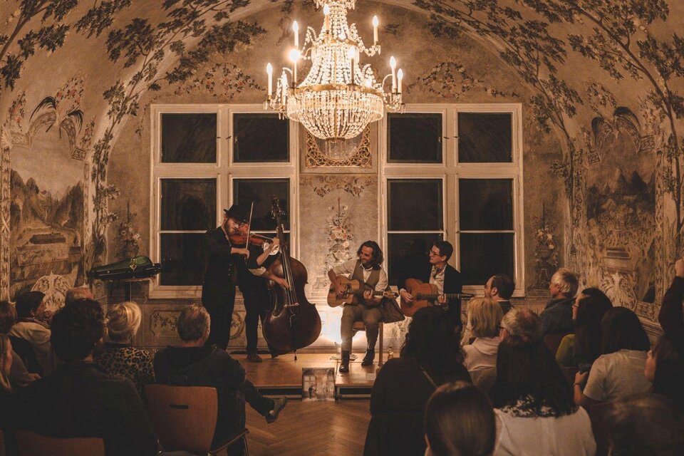 Im historischen Kaisersaal des Kammerhofmuseums in Bad Aussee spielt die Band "Paganin Soatnquartett" ein stimmungsvolles Konzert. Zahlreiche Besucher lauschen den muskalischen Klängen. | © Kammerhofmuseum