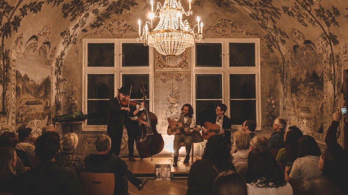 Im historischen Kaisersaal des Kammerhofmuseums in Bad Aussee spielt die Band "Paganin Soatnquartett" ein stimmungsvolles Konzert. Zahlreiche Besucher lauschen den muskalischen Klängen. | © Kammerhofmuseum