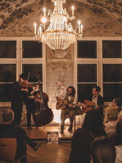 In the historic Kaisersaal of the Kammerhofmuseum in Bad Aussee, the band "Paganin Soatnquartett" performs an atmospheric concert. Numerous visitors listen to the musical sounds. | © Kammerhofmuseum
