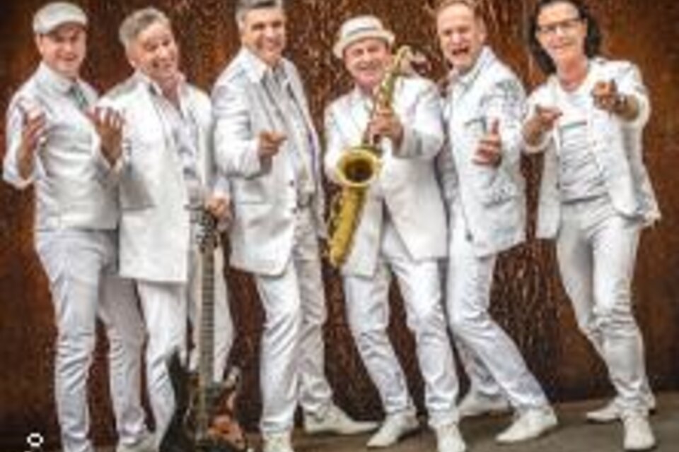 Eine Gruppe von sechs Musikern in weißen Anzügen, die fröhlich posieren. Ein Saxophonist hält sein Instrument, während die anderen Instrumente präsentieren. | © BePo