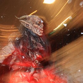 A creepy creature with horns and a grotesque face stands in a snowy environment. The movement and lights give the image a dark atmosphere. | © Graz Tourismus-Harry Schiffer