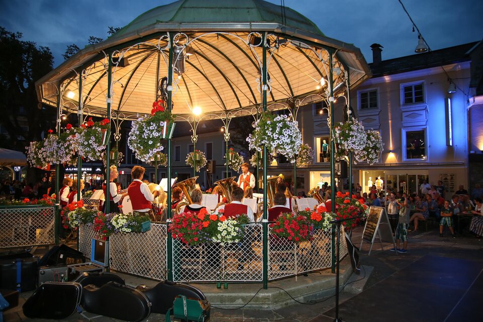 Ein schöner Pavillon mit Blumen und Lichtern, in dem eine Band spielt. Die Umgebung ist festlich beleuchtet und es sind viele Menschen zu sehen. | © Harald Steiner