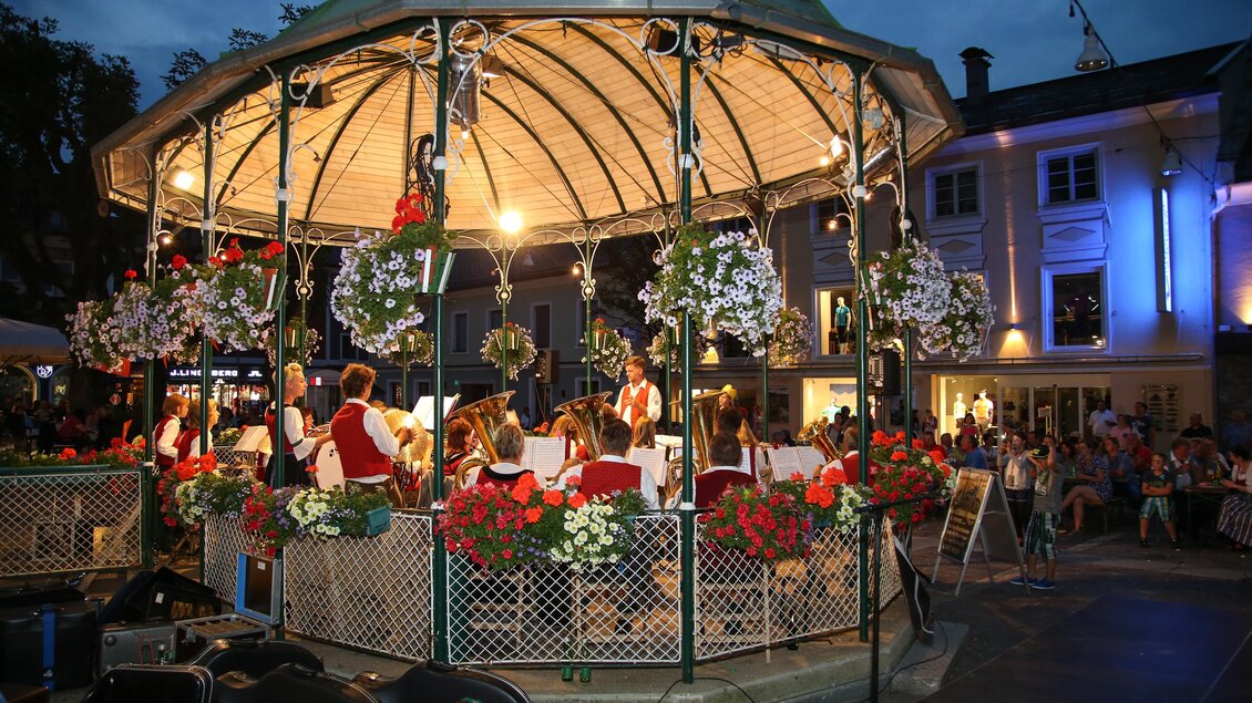 Ein schöner Pavillon mit Blumen und Lichtern, in dem eine Band spielt. Die Umgebung ist festlich beleuchtet und es sind viele Menschen zu sehen. | © Harald Steiner
