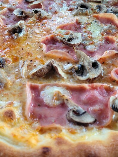 Eine leckere Pizza mit Schinken und Champignons. Der Teig ist goldbraun und knusprig. | © TV Südsteiermark - Irene Löschnig