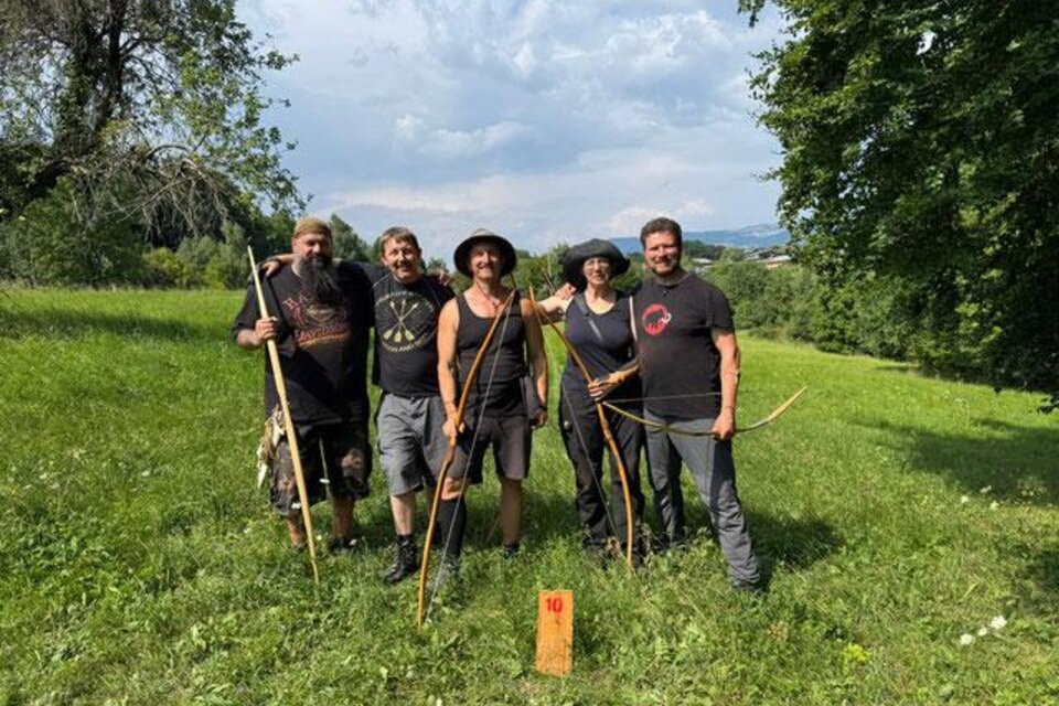 Eine Gruppe von fünf Personen steht in einer grünen Wiese. Sie halten Bögen und lächeln in die Kamera. | © Gerhard Wiesler
