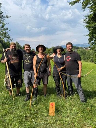 Eine Gruppe von fünf Personen steht in einer grünen Wiese. Sie halten Bögen und lächeln in die Kamera. | © Gerhard Wiesler