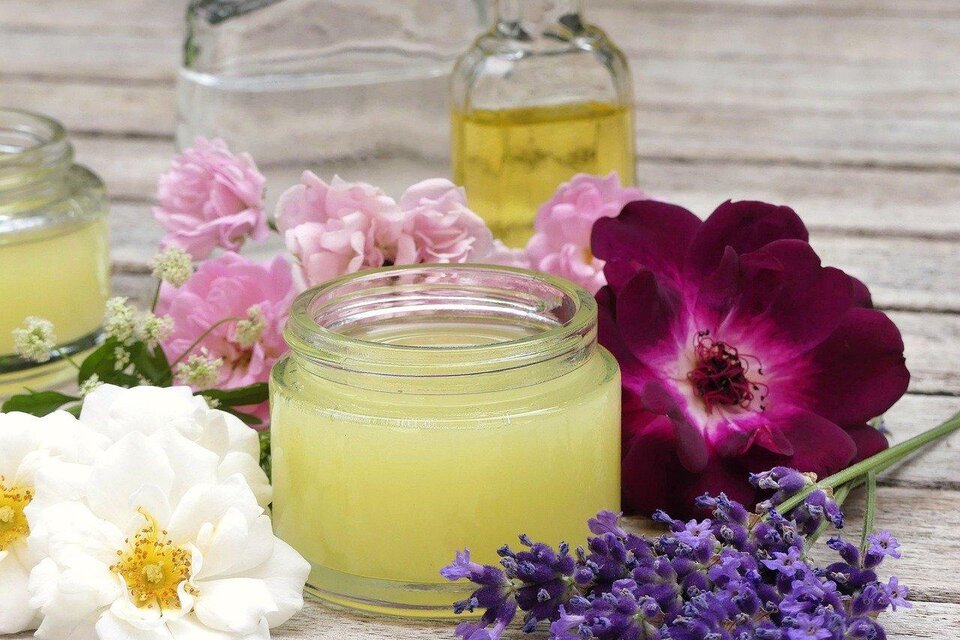 Das Bild zeigt ein kleines Gefäß mit einer Creme aus Naturkosmetik. Rundherum sind verschieden färbige Blüten | © pixabay.com