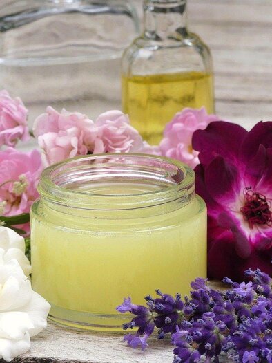 Das Bild zeigt ein kleines Gefäß mit einer Creme aus Naturkosmetik. Rundherum sind verschieden färbige Blüten | © pixabay.com