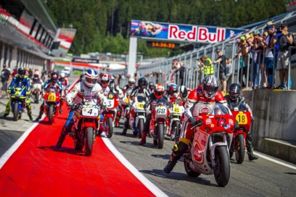 Eine Gruppe von Motorrädern startet auf einer Rennstrecke. Zuschauer stehen an der Seite und beobachten das Geschehen. | © Lucas Pripfl