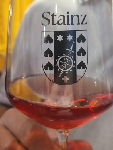 Ein Weinglas mit dem Wappen von Stainz. Der Inhalt ist ein rötlicher Wein. | © TV Südsteiermark - Irene Löschnig