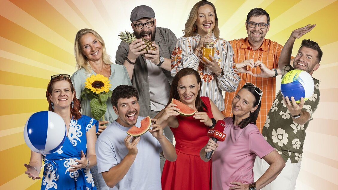 Eine fröhliche Gruppe von Menschen, die sich zusammen amüsieren. Sie halten verschiedene sommerliche Gegenstände und genießen die sunny Atmosphäre. | © ORF/Regine Schöttl