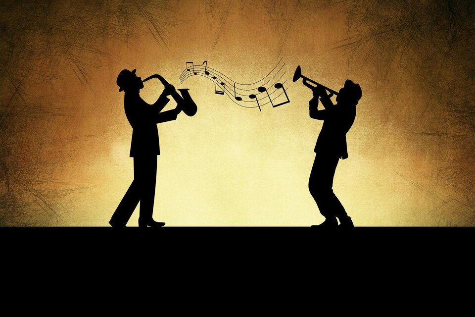 Zwei Silhouetten von Musikern spielen Saxophon und Trompete. Über ihnen schweben Musiknoten vor einem warmen, goldenen Hintergrund. | © Pixabay