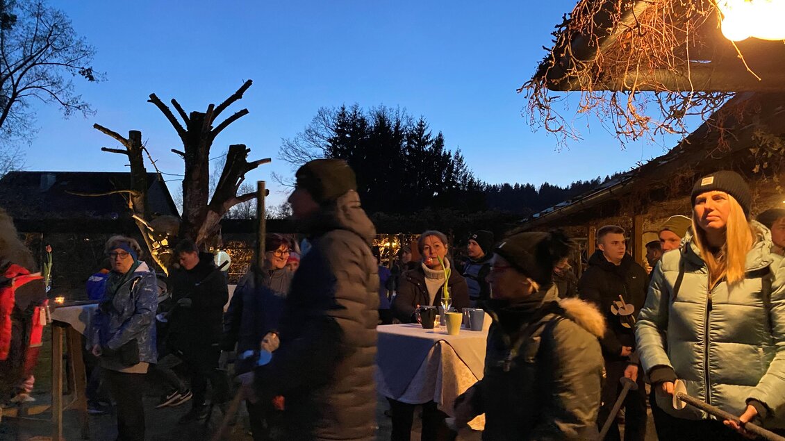 Eine Gruppe von Menschen versammelt sich im Freien bei Dämmerung. Es sind Lichter und Stände sichtbar, die eine gemütliche Atmosphäre schaffen. | © CDM
