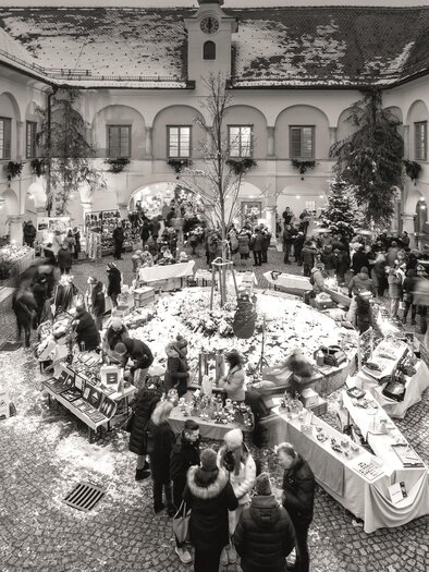 Ein gemütlicher Weihnachtsmarkt mit vielen Ständen und fröhlichen Menschen. Schneebedeckte Landschaften sorgen für eine festliche Atmosphäre. | © Retzhof_Niki Schreinlechner