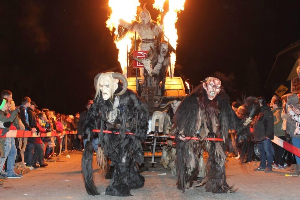 Ein festlicher Umzug mit grotesken Masken und Kostümen. Die Szene ist lebhaft, mit Menschenmengen und flammendem Feuer im Hintergrund. | © Lembacher Eisteifln