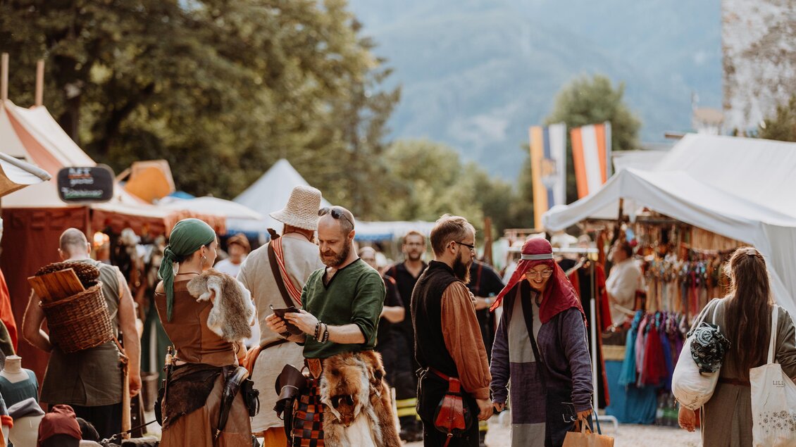 Ein lebhafter Mittelaltermarkt mit vielen kostümierten Menschen. Verkaufsstände und bunte Zelte prägen die Szene. | © TV Hochsteiermark, nicoleseiser.at