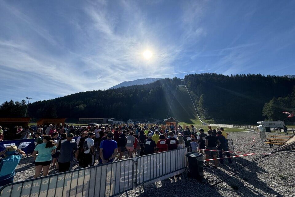 Eine große Gruppe von Menschen versammelt sich in einer landschaftlichen Umgebung. Im Hintergrund sind Berge und ein klarer Himmel zu sehen. | © Auszeit Ausseerland